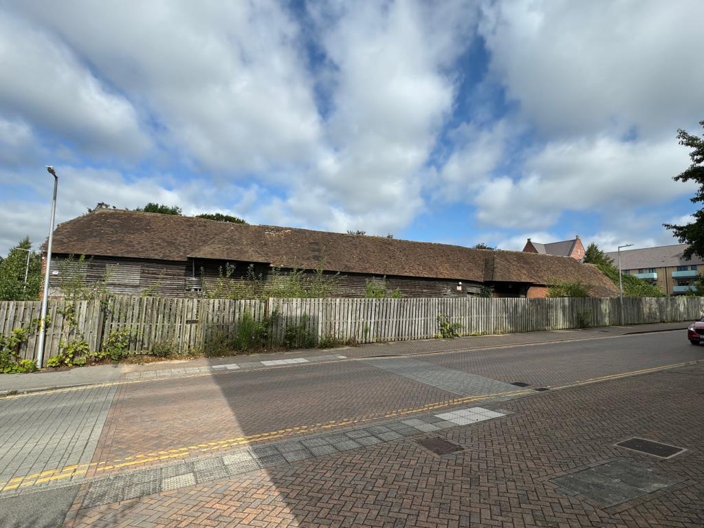 Lot: 109 - FREEHOLD BARN COMPLEX ON ALMOST THREE QUARTERS OF AN ACRE WITH POTENTIAL - Long Barn from Waitrose side of the road